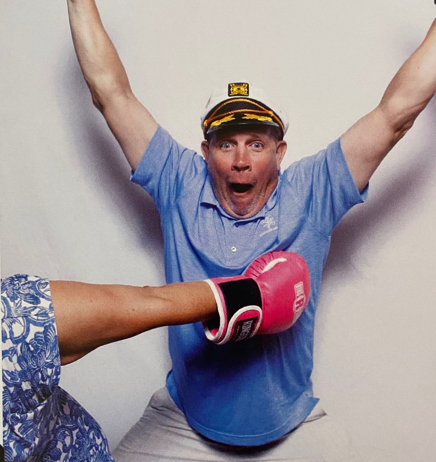 Aaron celebrating with arms raised in a captain's hat